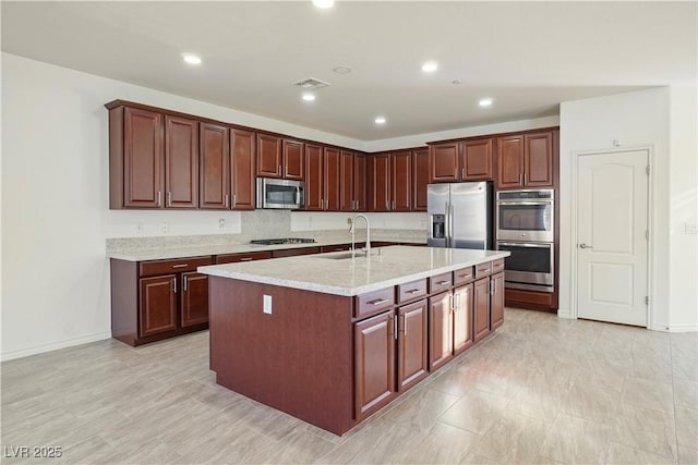 kitchen featuring visible vents, a sink, recessed lighting, appliances with stainless steel finishes, and a kitchen island with sink