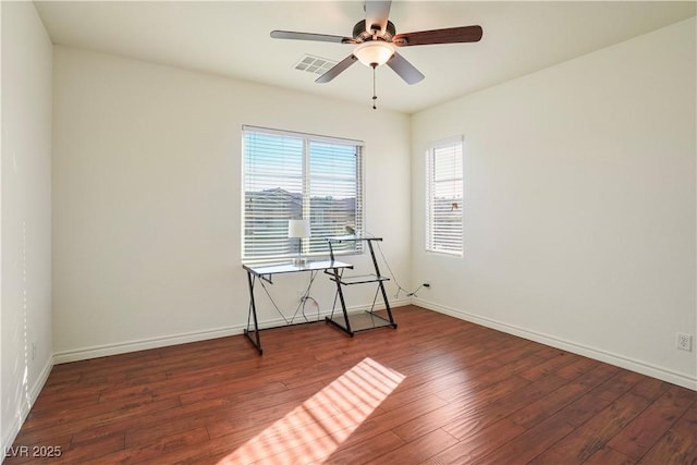 empty room featuring visible vents, wood-type flooring, baseboards, and ceiling fan