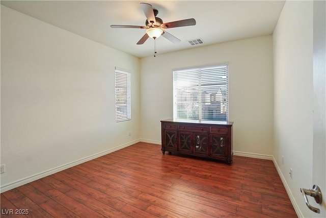 spare room featuring visible vents, wood-type flooring, baseboards, and ceiling fan