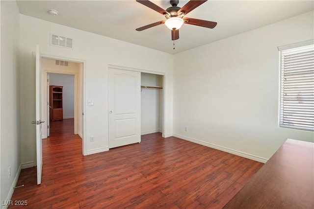 unfurnished bedroom with visible vents, baseboards, a closet, and wood finished floors