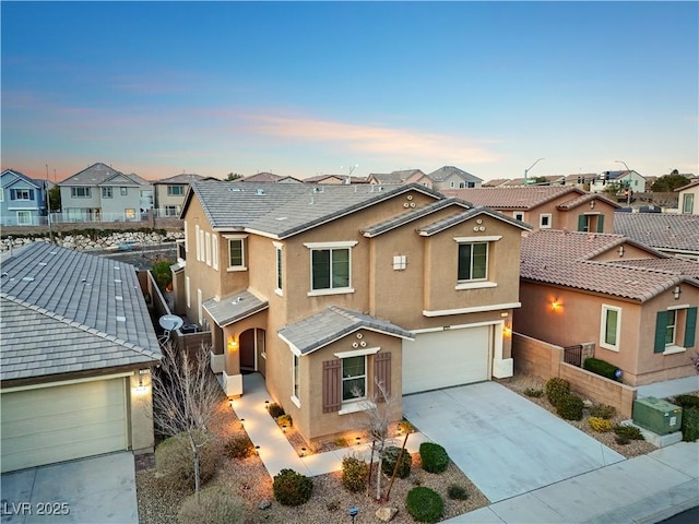 view of front facade with concrete driveway, fence, a residential view, and stucco siding