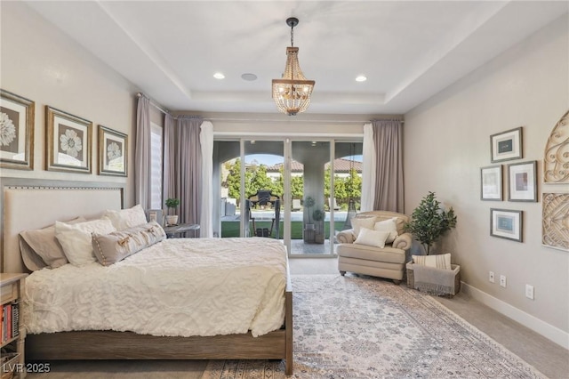 carpeted bedroom with baseboards, recessed lighting, access to exterior, a raised ceiling, and a notable chandelier