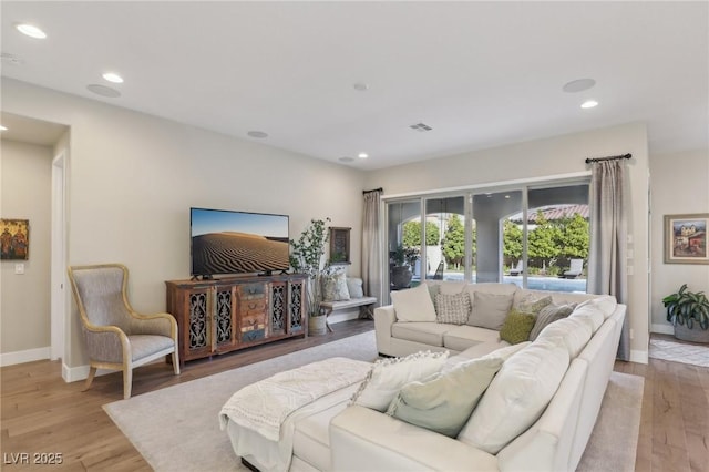 living area with visible vents, recessed lighting, light wood-type flooring, and baseboards