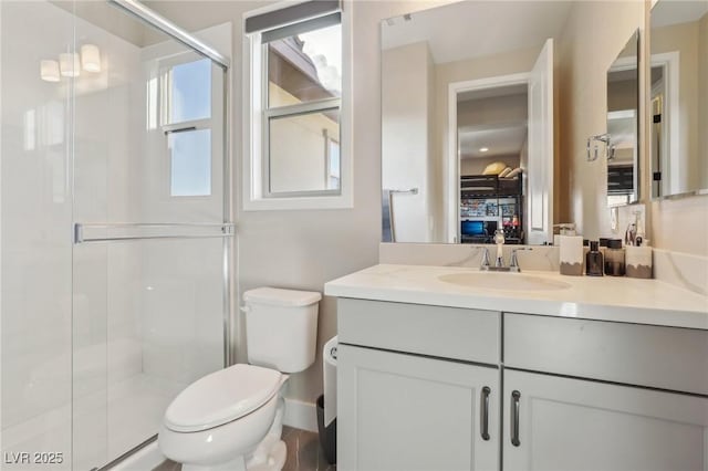 bathroom featuring vanity, toilet, and a shower stall