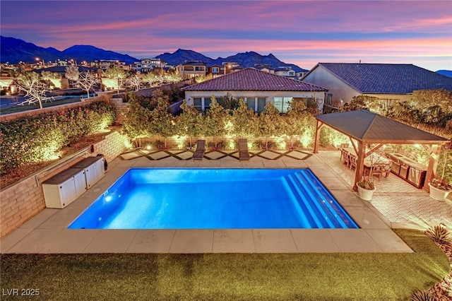 view of pool featuring a mountain view, a fenced in pool, a fenced backyard, and a patio area