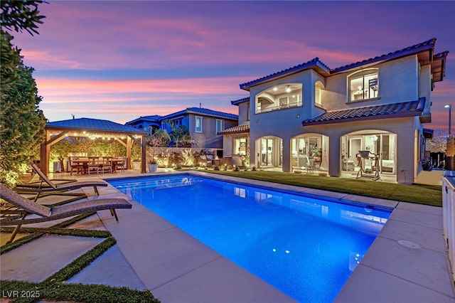 outdoor pool with outdoor dining space, a gazebo, a yard, and a patio area