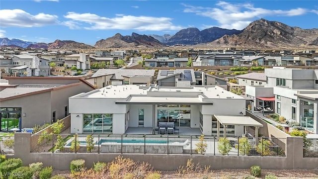 rear view of house with a residential view, a fenced in pool, a fenced backyard, a mountain view, and stucco siding