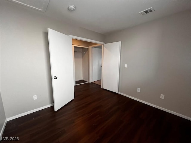 unfurnished bedroom featuring visible vents, baseboards, and wood finished floors