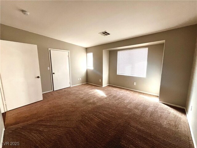 spare room with visible vents, baseboards, and carpet flooring