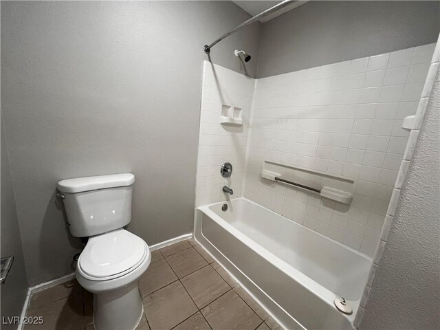 bathroom with tile patterned flooring, toilet, shower / bath combination, and baseboards