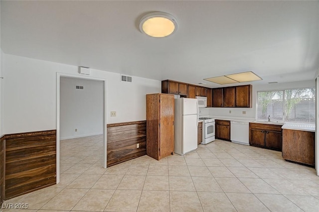 kitchen featuring visible vents, white appliances, light tile patterned flooring, and light countertops