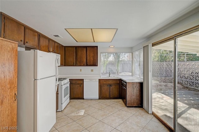 kitchen with visible vents, white appliances, light tile patterned flooring, and light countertops