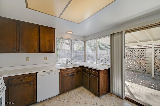 kitchen featuring light tile patterned floors, a sink, light countertops, dark brown cabinetry, and dishwasher