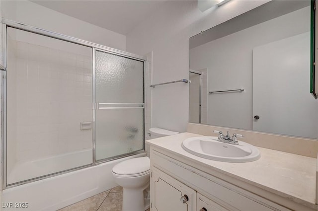 bathroom with tile patterned flooring, toilet, vanity, and enclosed tub / shower combo