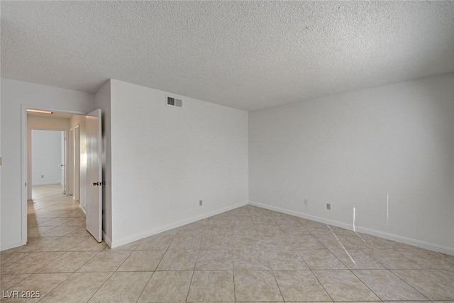 unfurnished room featuring light tile patterned floors, baseboards, visible vents, and a textured ceiling