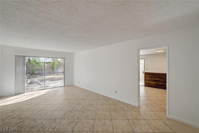 unfurnished room featuring baseboards, a textured ceiling, and light tile patterned flooring