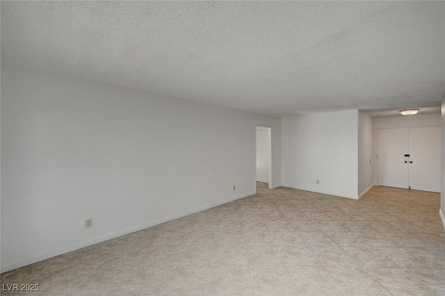 unfurnished room featuring baseboards and a textured ceiling