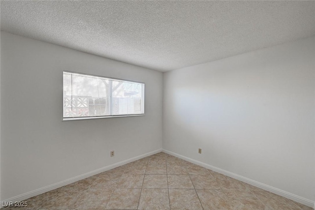 unfurnished room featuring light tile patterned floors, baseboards, and a textured ceiling