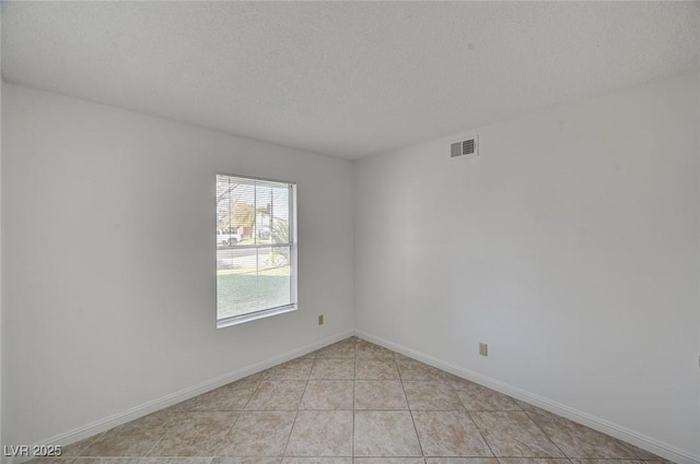 unfurnished room featuring light tile patterned flooring, baseboards, visible vents, and a textured ceiling