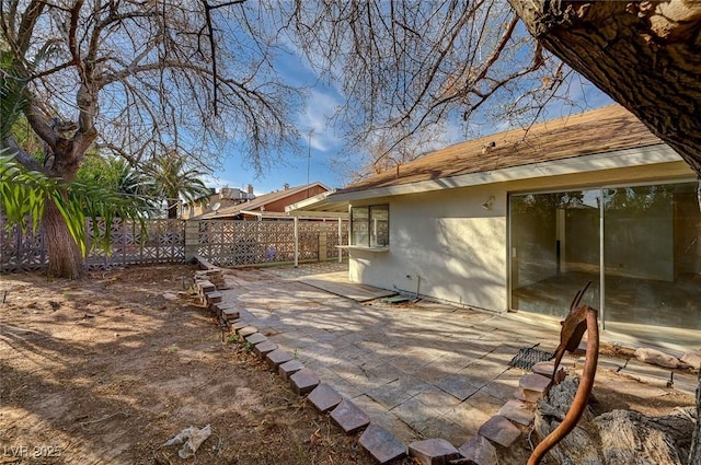 exterior space with a patio area, stucco siding, and fence