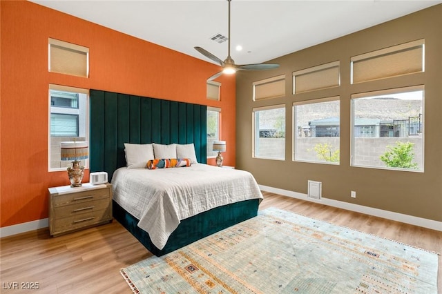 bedroom with visible vents, baseboards, and light wood finished floors