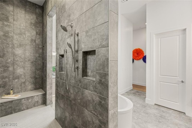 bathroom featuring visible vents, baseboards, and walk in shower