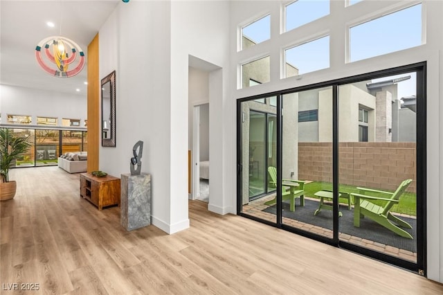 interior space featuring wood finished floors, baseboards, and a towering ceiling