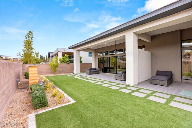 view of yard featuring outdoor lounge area, a patio, a fenced backyard, and ceiling fan