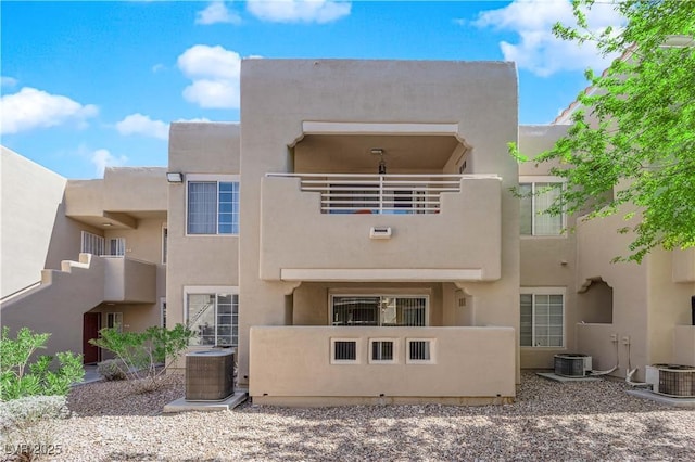 back of house featuring cooling unit, a balcony, and stucco siding