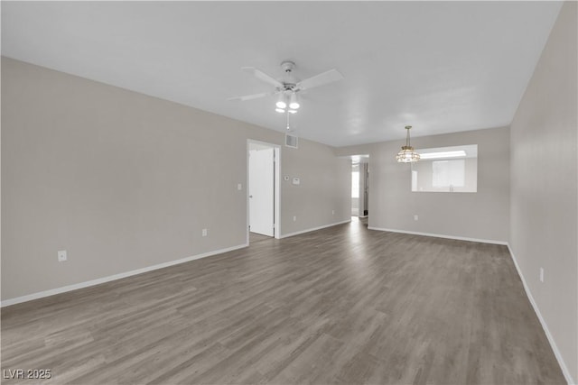 spare room featuring visible vents, baseboards, a ceiling fan, and wood finished floors