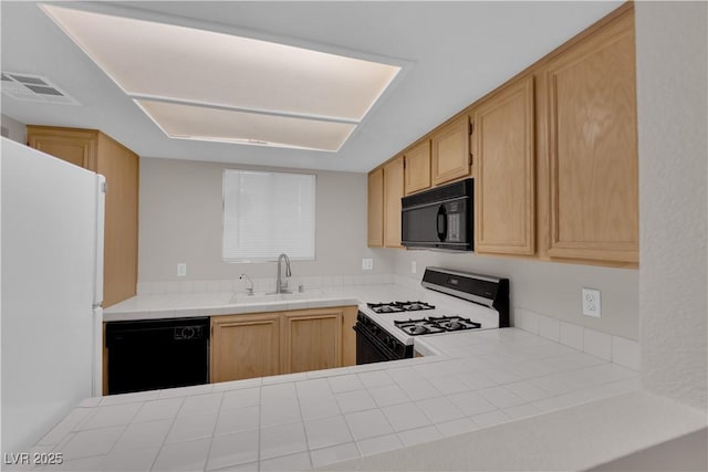 kitchen with light brown cabinets, visible vents, a sink, black appliances, and tile counters