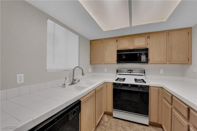 kitchen with a sink, tile countertops, black appliances, and light brown cabinets