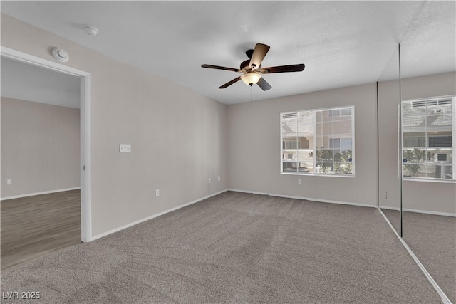 unfurnished bedroom featuring baseboards, carpet floors, and ceiling fan