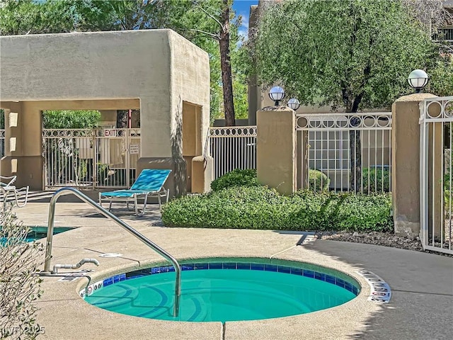 view of pool featuring a hot tub and fence