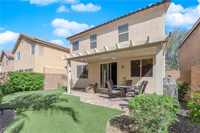 rear view of property featuring stucco siding, a patio, a fenced backyard, and a tiled roof