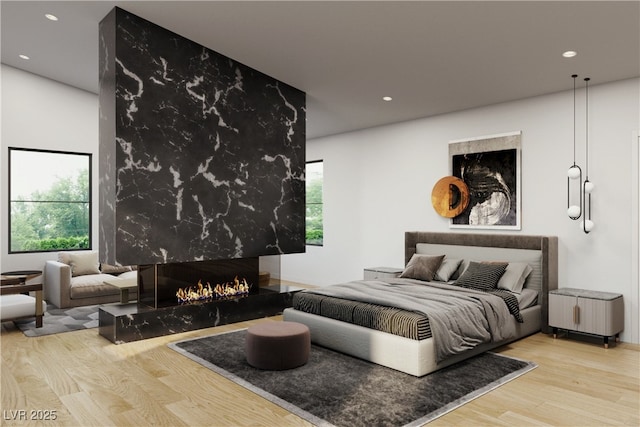 bedroom with recessed lighting, wood finished floors, and a high end fireplace