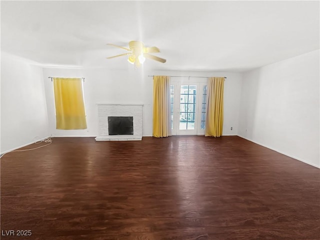 unfurnished living room with a fireplace, a ceiling fan, and wood finished floors