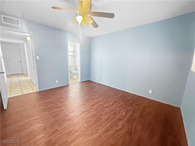 spare room featuring a ceiling fan, wood finished floors, and visible vents