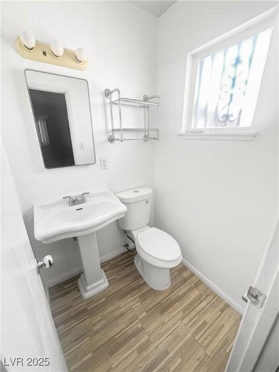 bathroom featuring baseboards, toilet, and wood finished floors