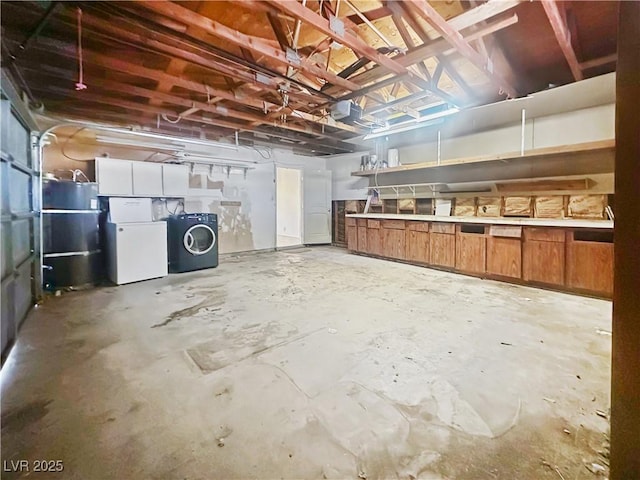 basement featuring washer / dryer, a garage, and freestanding refrigerator