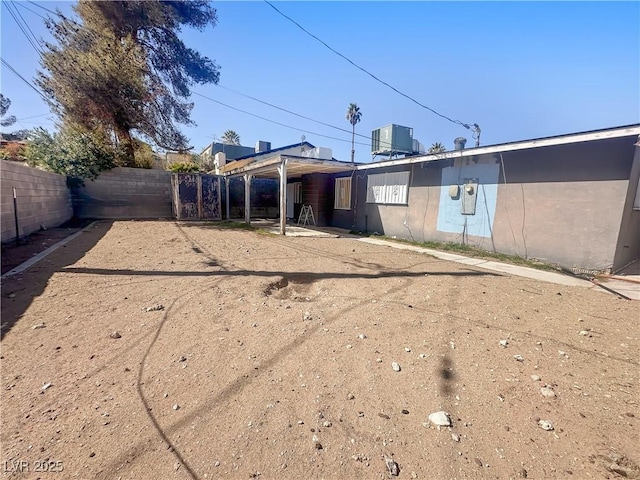 rear view of property with central air condition unit, a fenced backyard, and stucco siding