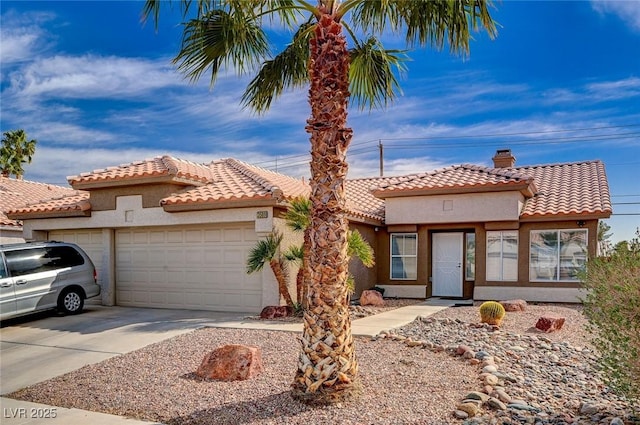 mediterranean / spanish home featuring an attached garage, a tile roof, stucco siding, a chimney, and driveway