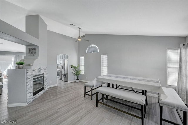 dining room with wood finished floors, visible vents, plenty of natural light, and a glass covered fireplace