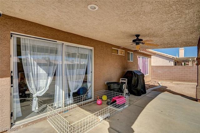 view of patio featuring area for grilling, a ceiling fan, and fence