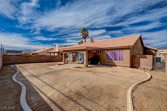 back of property featuring a patio, a fenced backyard, and a tile roof