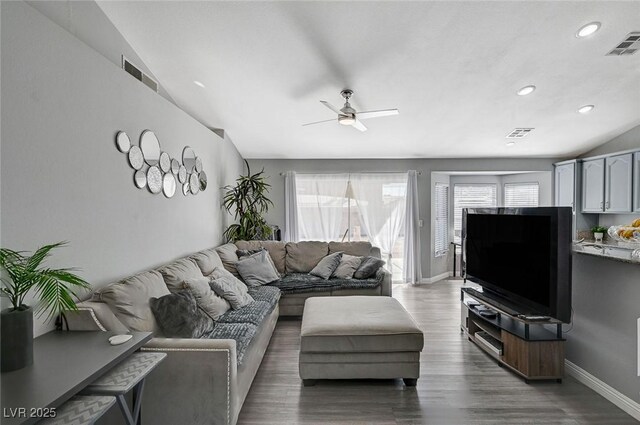 living area featuring wood finished floors, visible vents, and baseboards