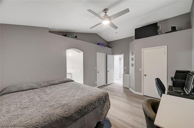 bedroom featuring ceiling fan, baseboards, light wood-type flooring, lofted ceiling, and arched walkways