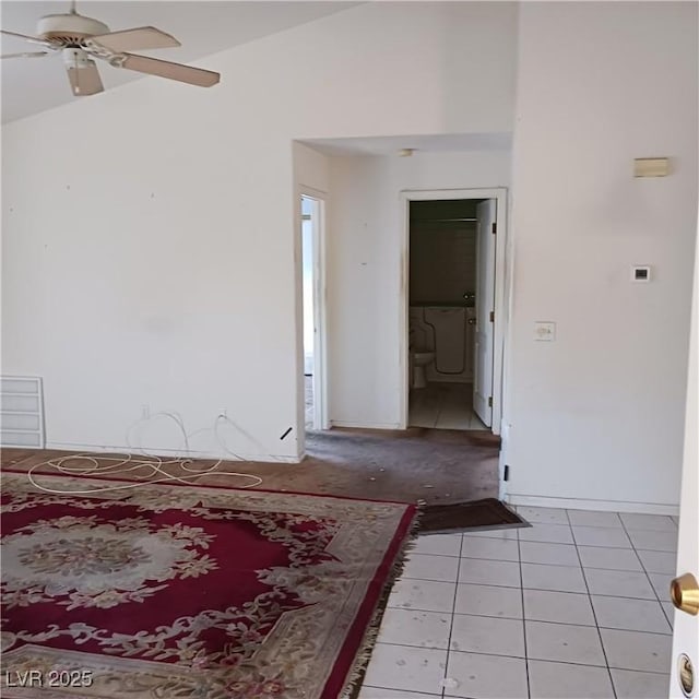 unfurnished room with lofted ceiling, light tile patterned flooring, and a ceiling fan