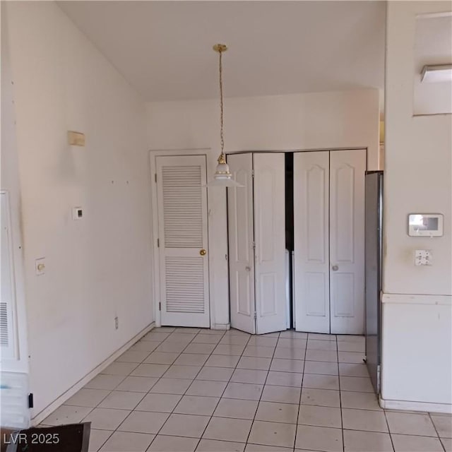 unfurnished bedroom featuring light tile patterned floors and a closet