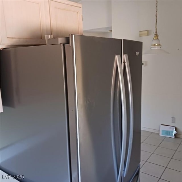 kitchen featuring light tile patterned floors, baseboards, and freestanding refrigerator